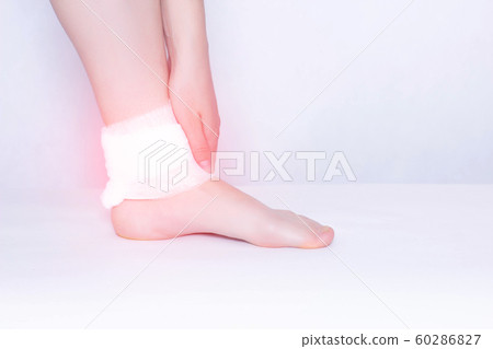 Compress and ankle support to eliminate pain, inflammation and dislocation of the ankle joint, close-up, copy space, osteoarthritis Compress and ankle support to eliminate pain, inflammation and dislocation of the ankle joint, close-up, copy space, osteoarthritis 60286827