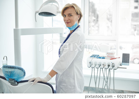 Grinning female dentist is enjoying break in office 60287097