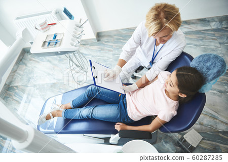 Merry adult dentist is consulting teenage lady Merry adult dentist is consulting teenage lady 60287285