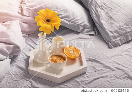 Tray with coffee, milk, orange and yellow flower in a vase. 60288436