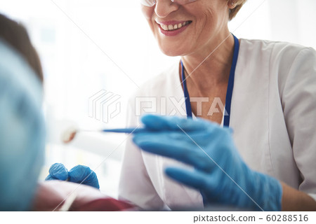 Close up of a smiling stomatologist enjoying her work 60288516