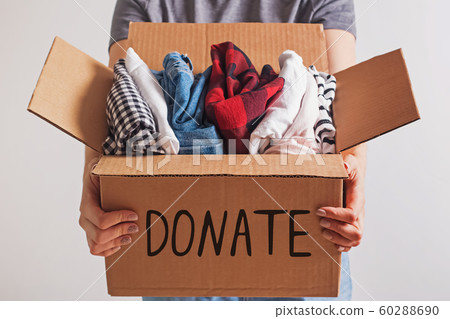 Woman holding a box with clothing close-up. 60288690