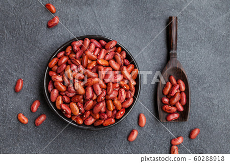 Red kidney beans in a black bowl on grey stone background. Top view. 60288918