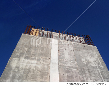 Reinforcement concrete column as part of building structure at the construction site. Constructed by workers using timber and metal formwork as a mold.   60289947