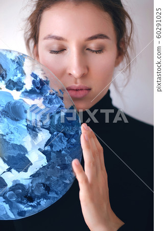 Girl with palette of trendy 2020 blue color paint Girl with palette of trendy 2020 blue color paint 60291025