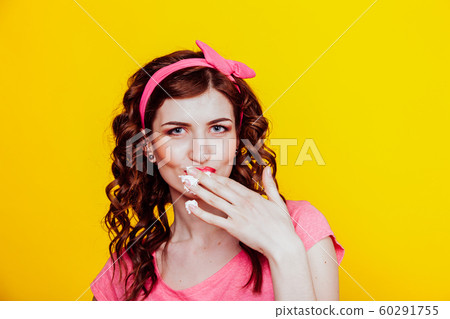 girl in pink dress pinup-style eats cream licks fingers girl in pink dress pinup-style eats cream licks fingers 60291755
