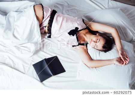 girl in pajamas lying on the bed with a book before bed girl in pajamas lying on the bed with a book before bed 60292075