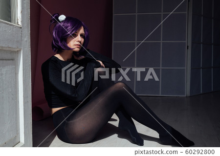 Beautiful woman anime cosplayer with purple hair in black fashion clothes Beautiful woman anime cosplayer with purple hair in black fashion clothes 60292800