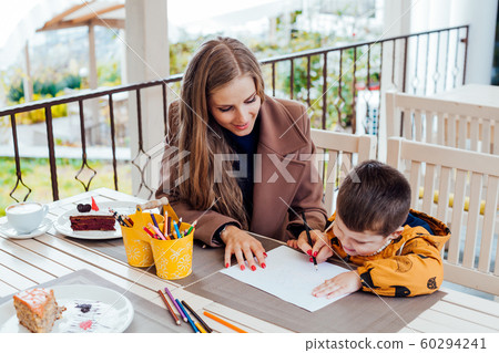 mom helps son to draw drawing colored pencils mom helps son to draw drawing colored pencils 60294241