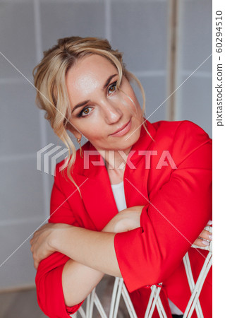 Beautiful blonde woman in red business suit in business office Beautiful blonde woman in red business suit in business office 60294510