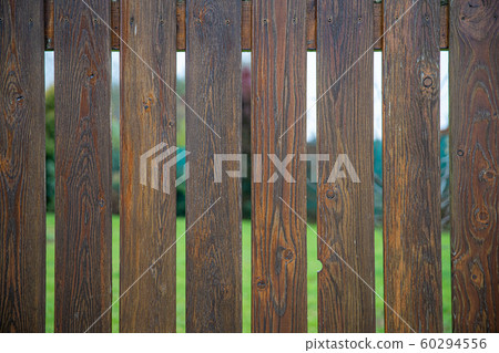 wooden fence in front of green garden of family house 60294556