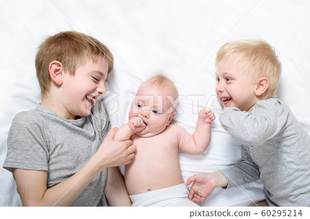 Two older brothers play and laugh with the Two older brothers play and laugh with the 60295214