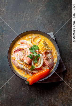 Peruvian seafood soup Chupe de Camarones in gray bowl, top view 60295421