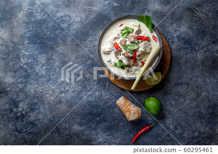 Thai chicken mushroom coconut milk soup TOM KHA GAI in bowl with thai spices. 60295461