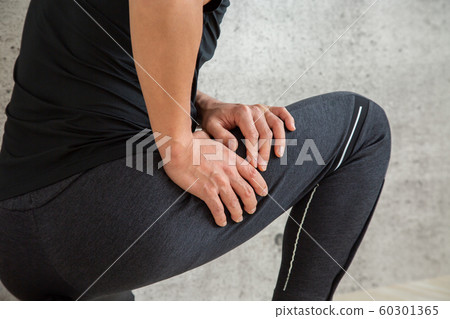 A man holding his thighs during exercise (hamstring/thigh/muscle pain) 60301365