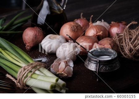 Fresh onion and garlic on wood plate 60303155