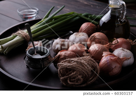 Fresh onion and garlic on wood plate 60303157