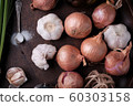 Fresh onion and garlic on wood plate 60303158