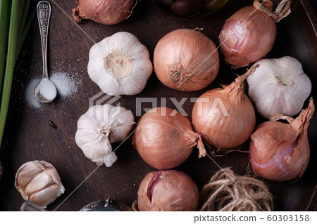 Fresh onion and garlic on wood plate 60303158