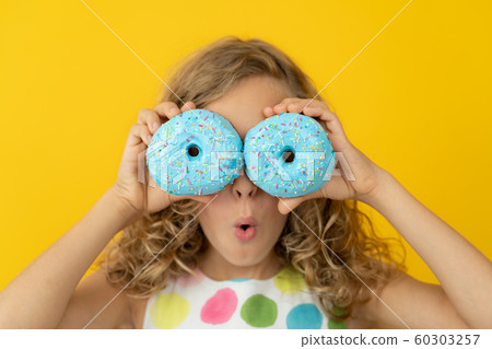 Happy child holding glazed donut Happy child holding glazed donut 60303257