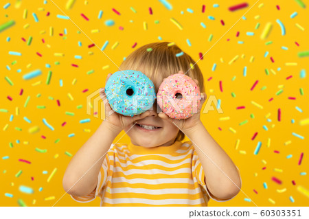 Happy child holding glazed donut Happy child holding glazed donut 60303351