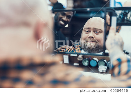 Handsome man looking at mirror in barber shop 60304456