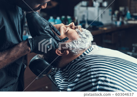 Focused master using blade to shaving client Focused master using blade to shaving client 60304637