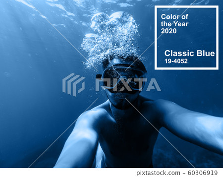 Classic Blue pantone color of the Year 2020. male diver swims in the sea under water with a mask and snorkel Classic Blue pantone color of the Year 2020. male diver swims in the sea under water with a mask and snorkel 60306919