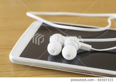 Close-up of smartphone and wireless earphone Close-up of smartphone and wireless earphone 60307315