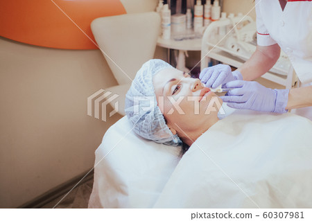 Cosmetology doctor makes injection in the lips Cosmetology doctor makes injection in the lips 60307981