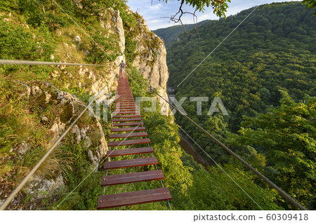 Man Walking on Via Ferrata Trail Man Walking on Via Ferrata Trail 60309418