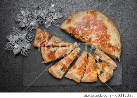 Stollen traditional Christmas cake made in a round 60312383