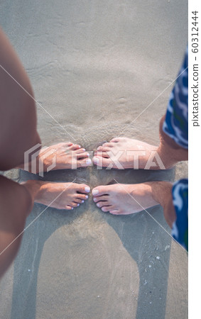 male and female feet on the sand 60312444