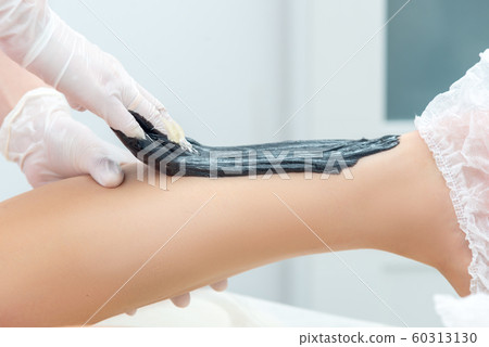 beautician hair removal procedure on the client's feet in beauty parlor beautician hair removal procedure on the client's feet in beauty parlor 60313130