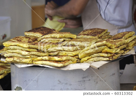 Malaysian street food called Murtabak. Cook by Hawkers. In it there is a mixture of meat, eggs and onions. Eaten with a special gravy. 60313302