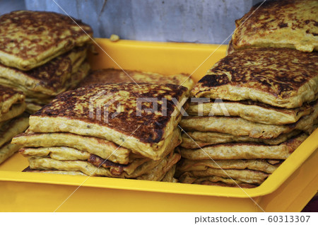 Malaysian street food called Murtabak. Cook by Hawkers. In it there is a mixture of meat, eggs and onions. Eaten with a special gravy. 60313307
