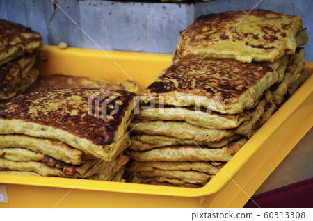 Malaysian street food called Murtabak. Cook by Hawkers. In it there is a mixture of meat, eggs and onions. Eaten with a special gravy. 60313308