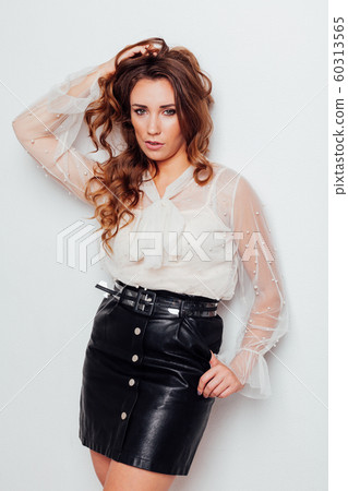 portrait of a beautiful fashionable woman with hair curls in a blouse and black skirt 60313565