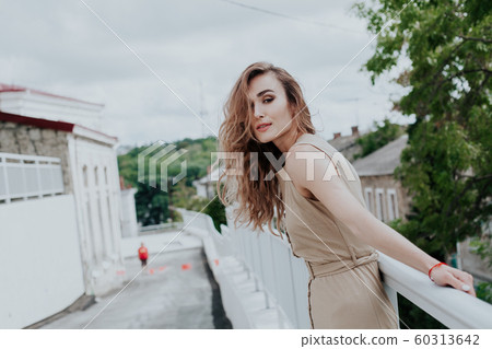 Portrait of a beautiful fashionable woman in a light gray dress 60313642