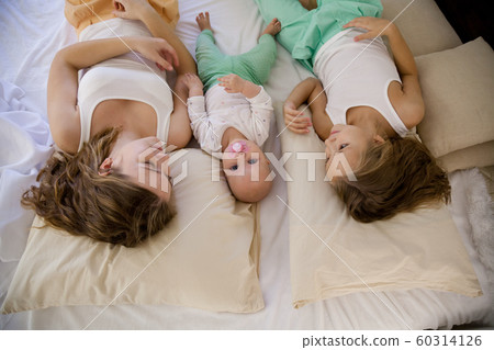 three sisters on the bed in the bedroom in the morning three sisters on the bed in the bedroom in the morning 60314126