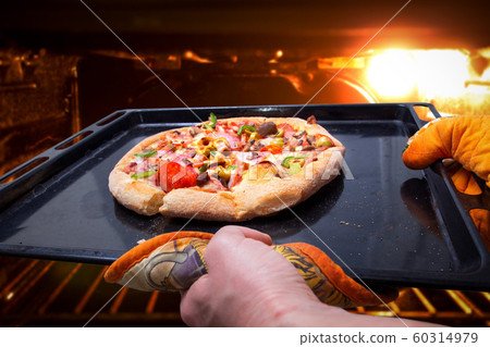 Pizza baked in oven. Woman's hands takes out pizza Pizza baked in oven. Woman's hands takes out pizza 60314979