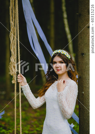 Beautiful young bride posing near the rope swing 60315216