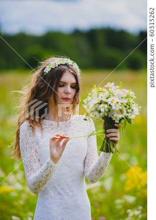Close-up portrait of a beautiful bride with chamomiles Close-up portrait of a beautiful bride with chamomiles 60315262