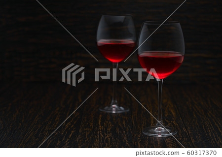 two glasses of red wine on a black wooden 60317370
