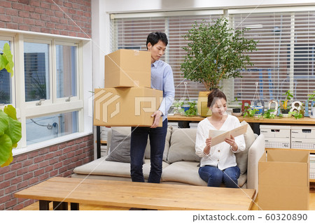 一個女人看著一個男人旁邊的紙板相冊 一個女人看著一個男人旁邊的紙板相冊 60320890