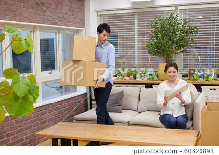 一個女人看著一個男人旁邊的紙板相冊 一個女人看著一個男人旁邊的紙板相冊 60320891