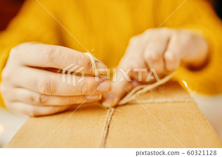 Woman packaging Christmas gift box. Woman packaging Christmas gift box. 60321128