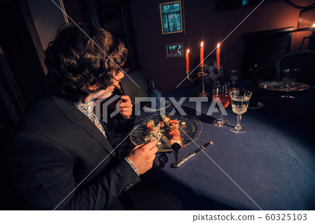 businessman dining in a restaurant by candlelight. Man eating barbecue. Concept of meat dishes, Caucasian cuisine, business lunch, romantic dinner businessman dining in a restaurant by candlelight. Man eating barbecue. Concept of meat dishes, Caucasian cuisine, business lunch, romantic dinner 60325103