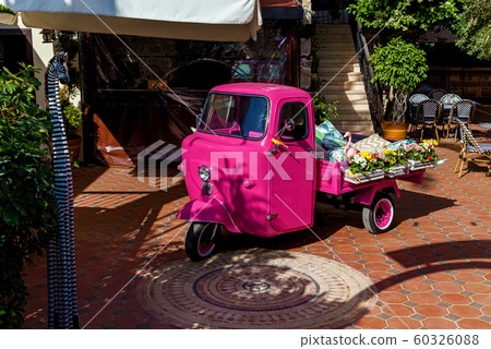 A small three-wheeled car stands on the empty A small three-wheeled car stands on the empty 60326088