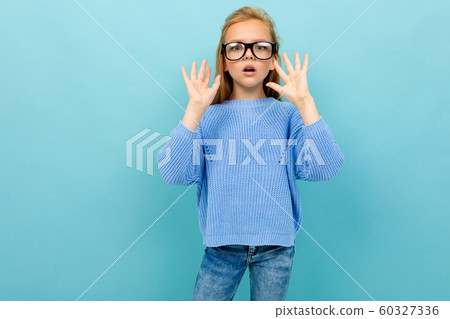 surprised european girl in glasses on a light blue background 60327336